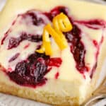 cranberry cheesecake swirl bar on plate with fork topped with orange