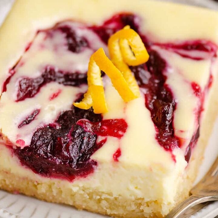 cranberry cheesecake swirl bar on plate with fork topped with orange