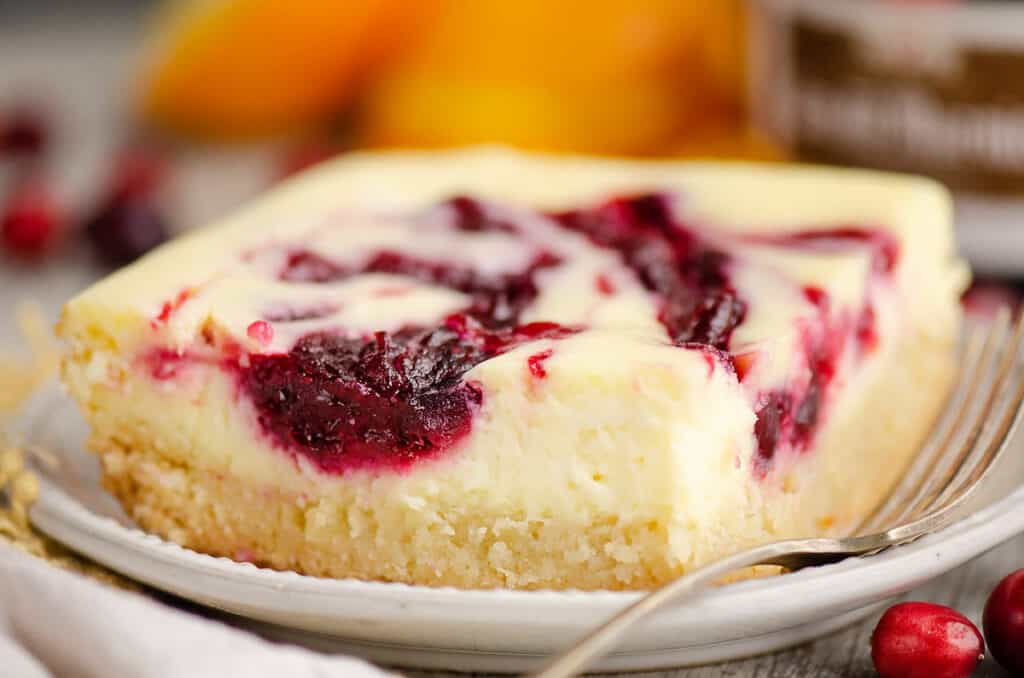 cranberry cheesecake swirl bar on plate with fork