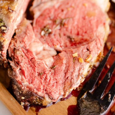 slice of garlic butter prime rib on cutting board with fork