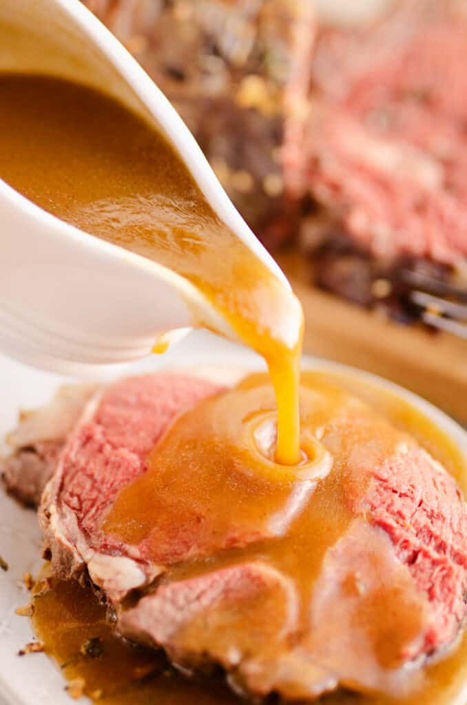 gravy poured over slice of garlic butter prime rib