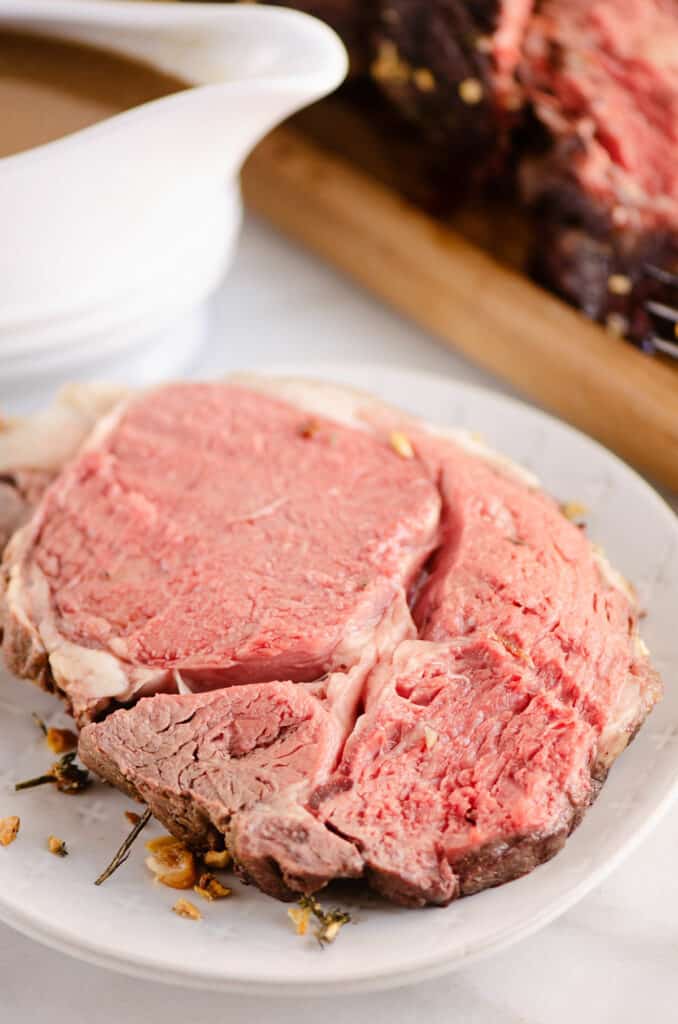 garlic butter prime rib served on plate with gravy boat