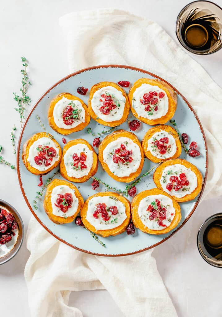 table with plate of sweet potato bites and cup of dried cranberries