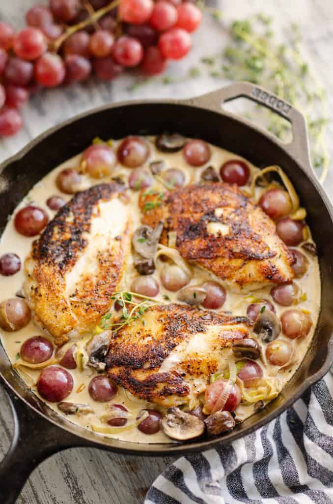 chicken and white wine cream sauce skillet on table with grapes