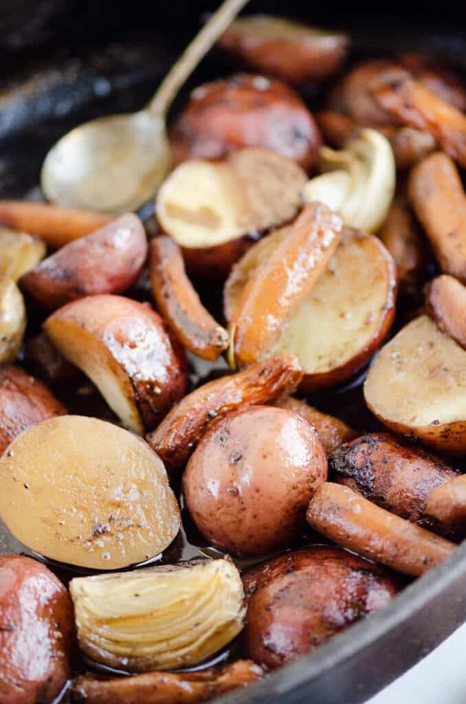 smoked potatoes and carrots in cast iron pan with red wine sauce
