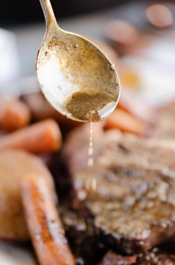 red wine sauce poured over pot roast and vegetables