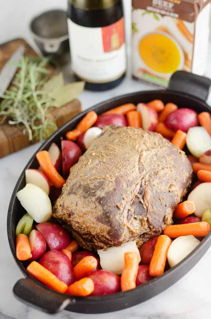 smoked pot roast on bed of vegetables in cast iron pan