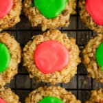 walnut thumbprint cookies with pink and green frosting on cooling rack