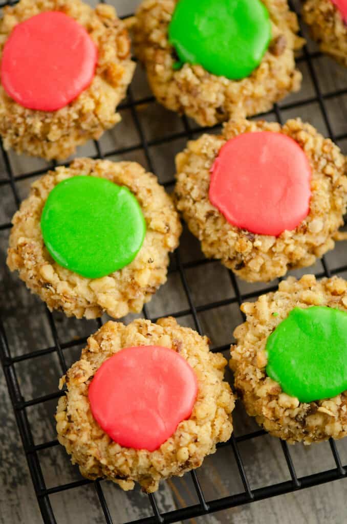 walnut thumbprint cookies with frosting on cooling rack