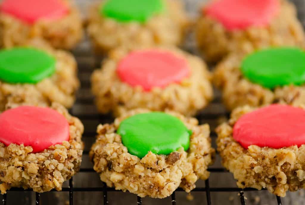 walnut thumbprint cookies with frosting on cooling wrack