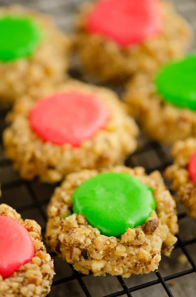 walnut thumbprint cookies with frosting on cooling rack