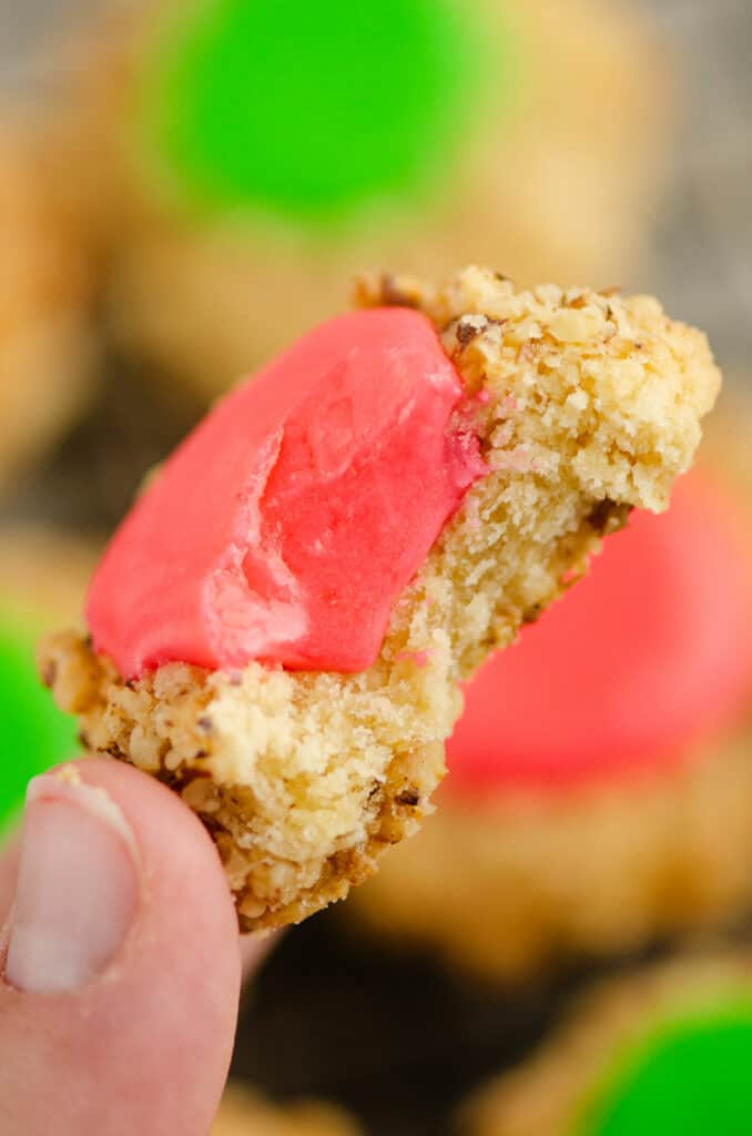 walnut thumbprint cookie with frosting with bit taken out of center