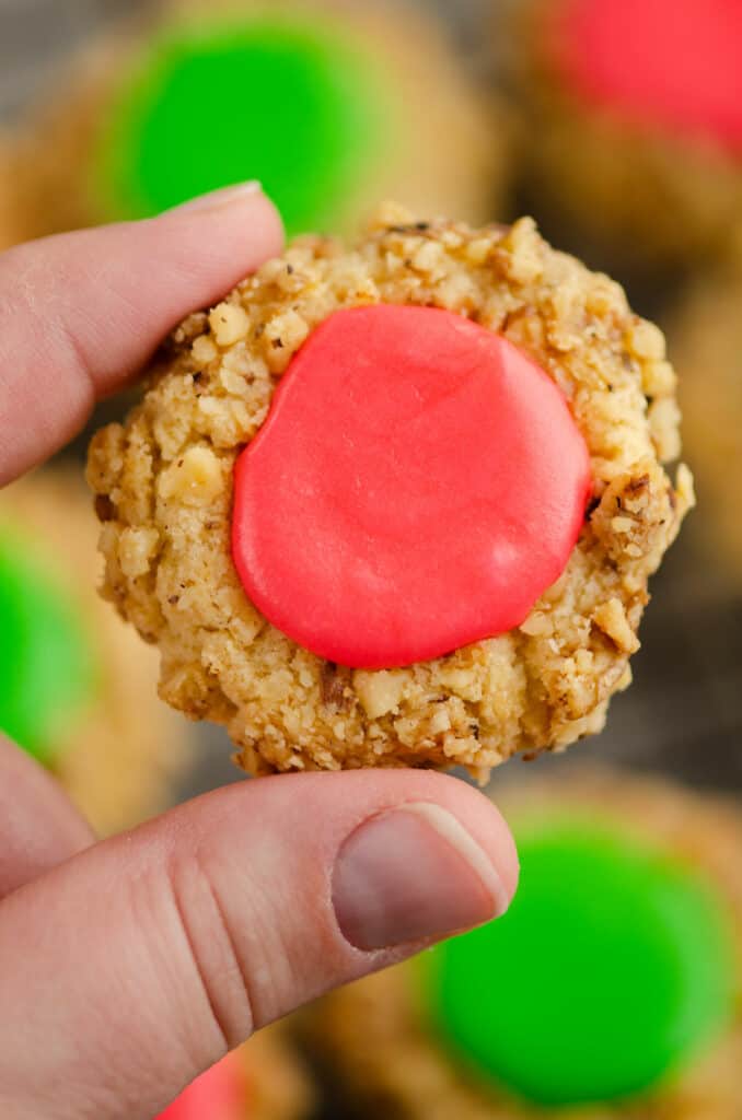 walnut thumbprint cookie with frosting held in hand