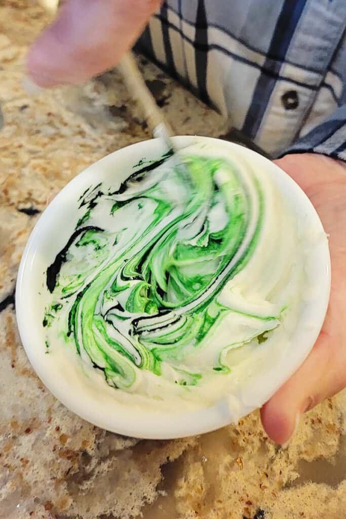 making green frosting in white bowl