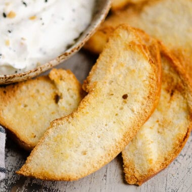 bagel chips on table next to sour cream dip