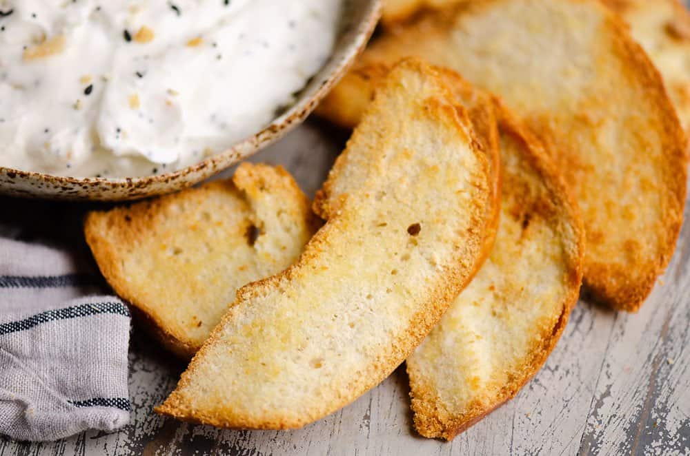 bagel chips on table next to sour cream dip