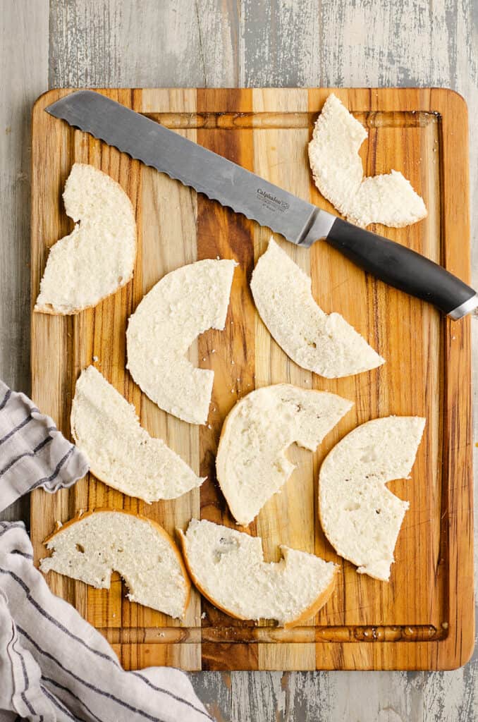 slices of bagel on a cutting board with knife