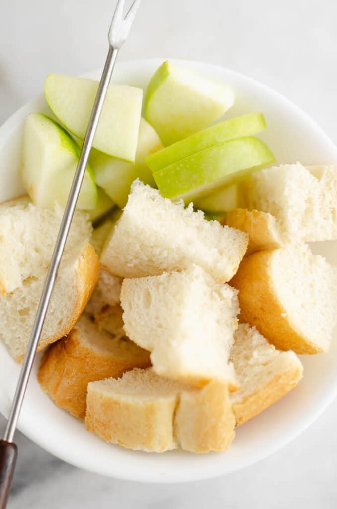 French bread and apples in bowl with fondue fork