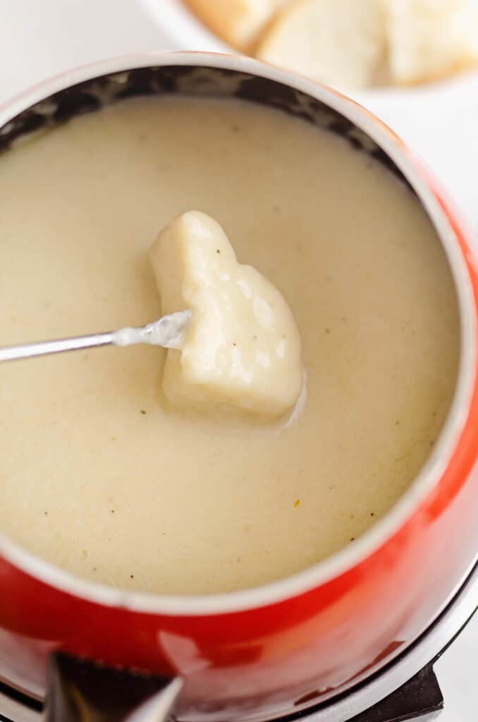 bread dipped in Swiss cheese fondue pot