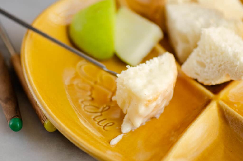 piece of bread on fondue fork with cheese fondue