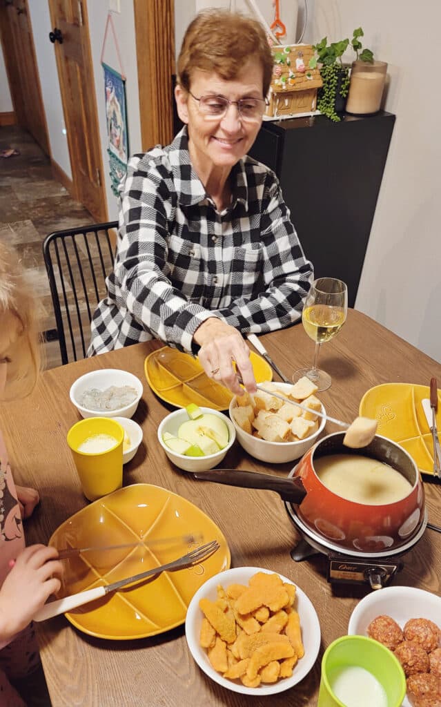 grandma eating cheese fondue at dinner table