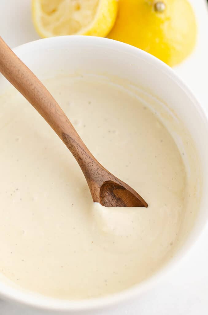 caesar dressing bowl with wooden spoon