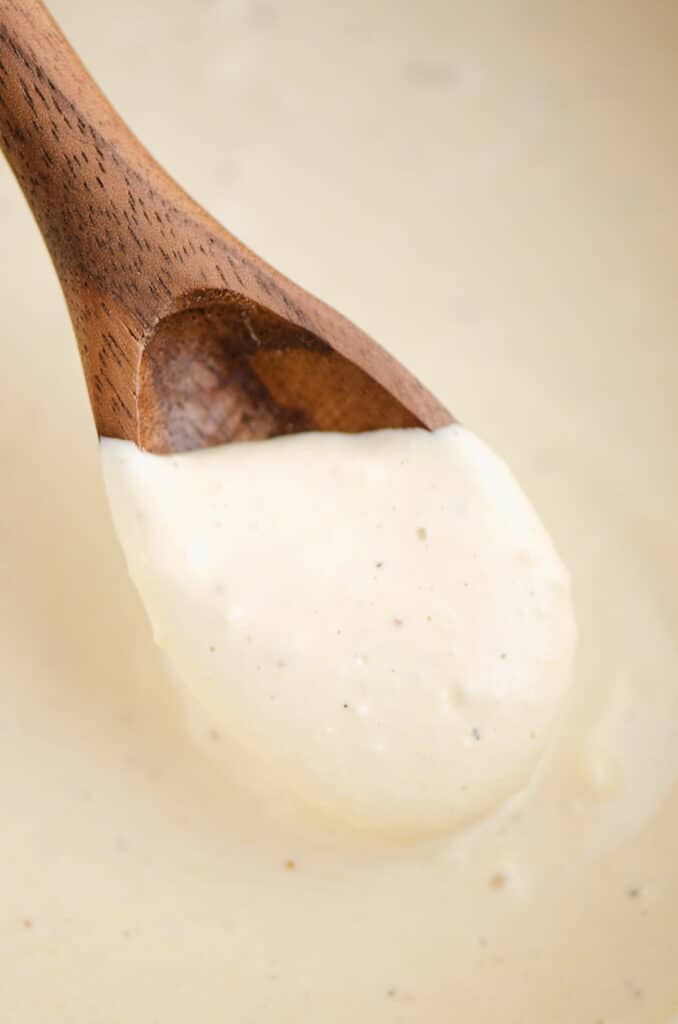 greek yogurt caesar dressing scooped with wooden spoon
