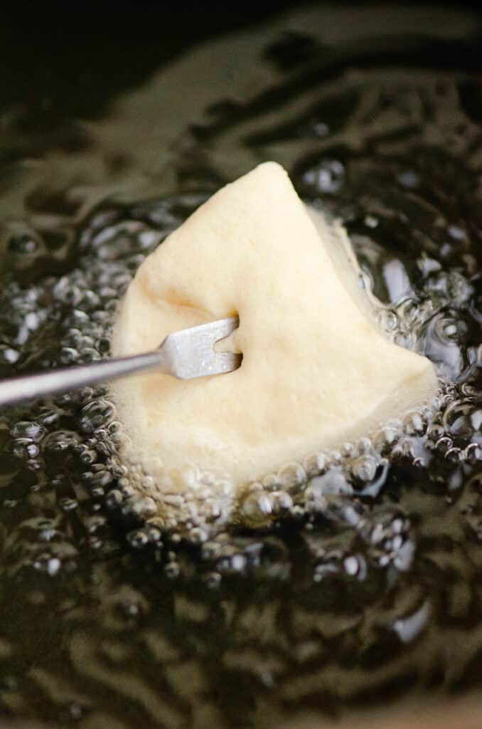 grands biscuit on fondue fork in hot oil