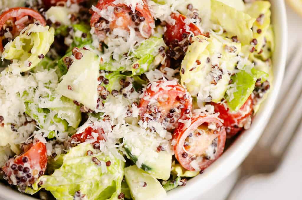 chopped caesar salad tossed in bowl on table