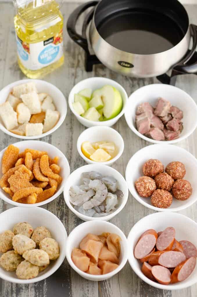 white bowls on table filled with fondue dippers