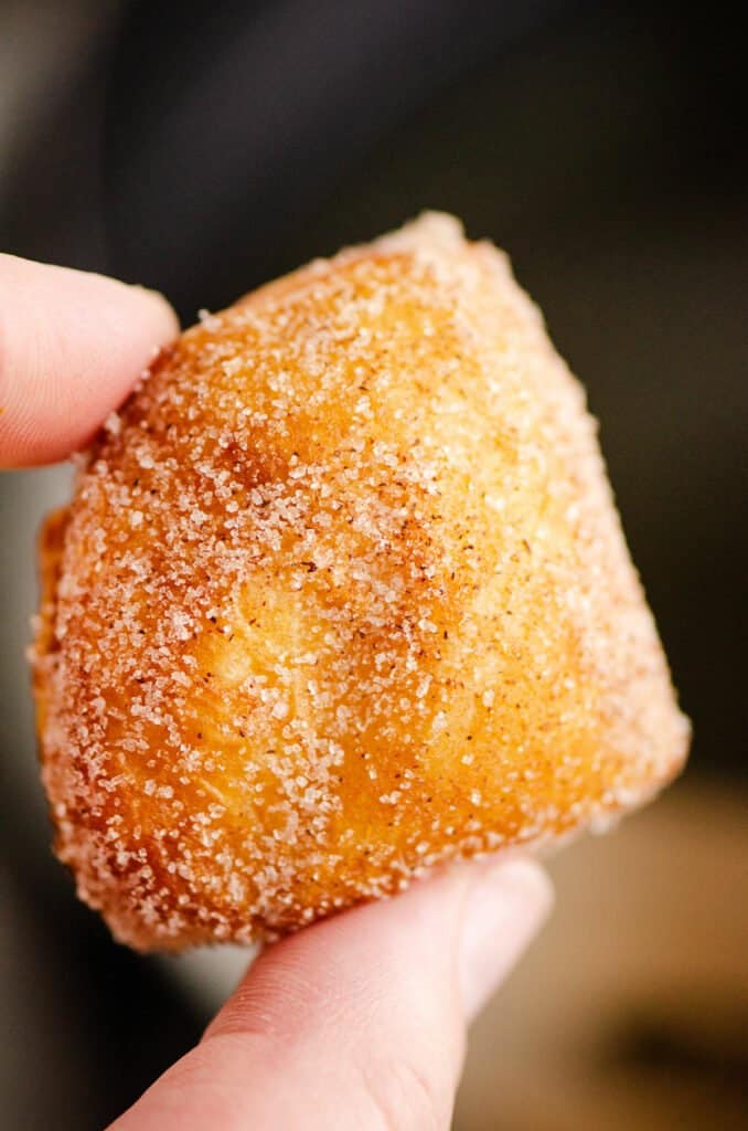 cinnamon sugar biscuit donut hole held with fingers