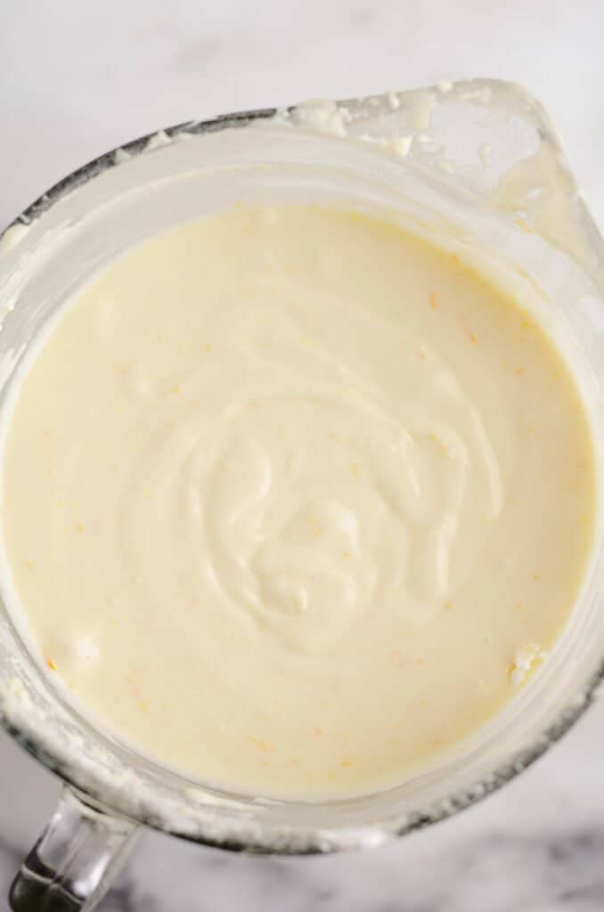 orange cupcake batter in glass bowl