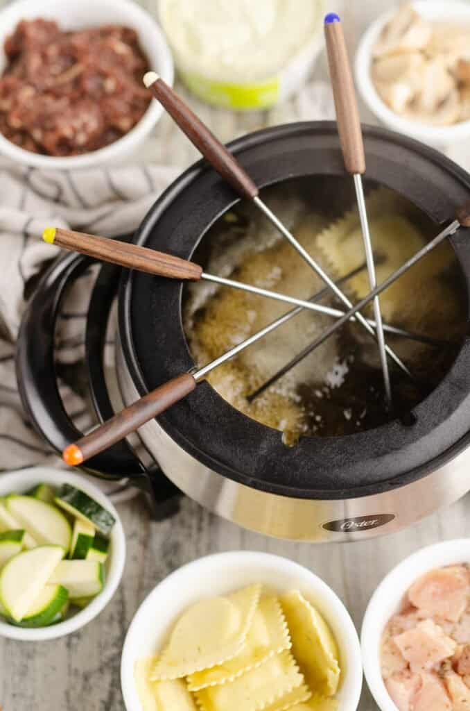 food on forks in broth fondue pot