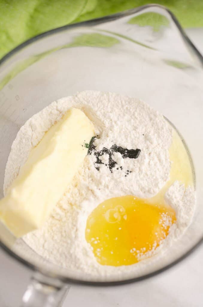 egg, butter and food dye with cake mix in bowl