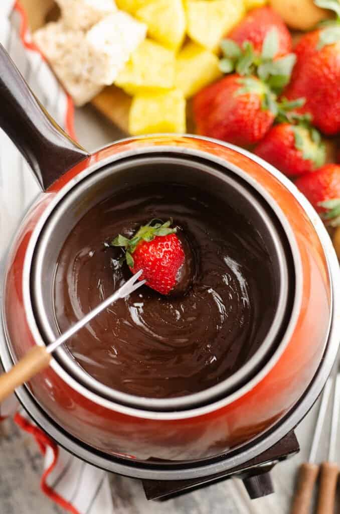 strawberry on fondue fork dipped in chocolate