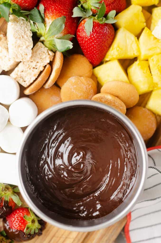 bowl of chocolate fondue served with dippers on board