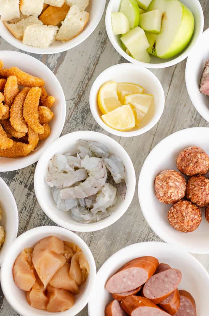 white bowls filled with fondue dippers on table