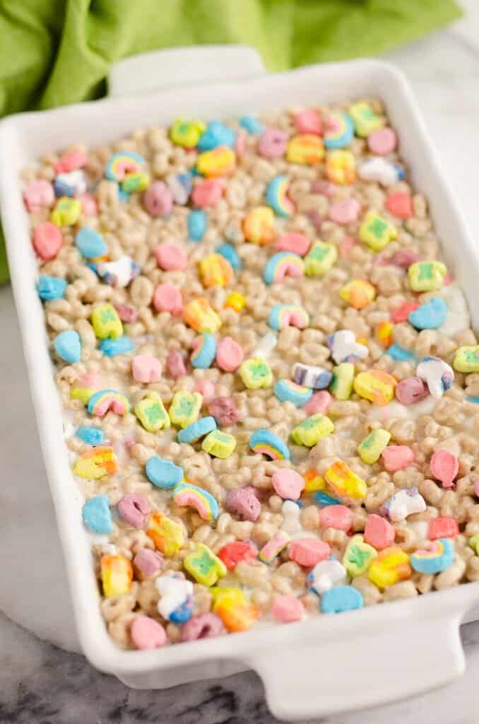 lucky charms topped cake bars in white pan with green napkin