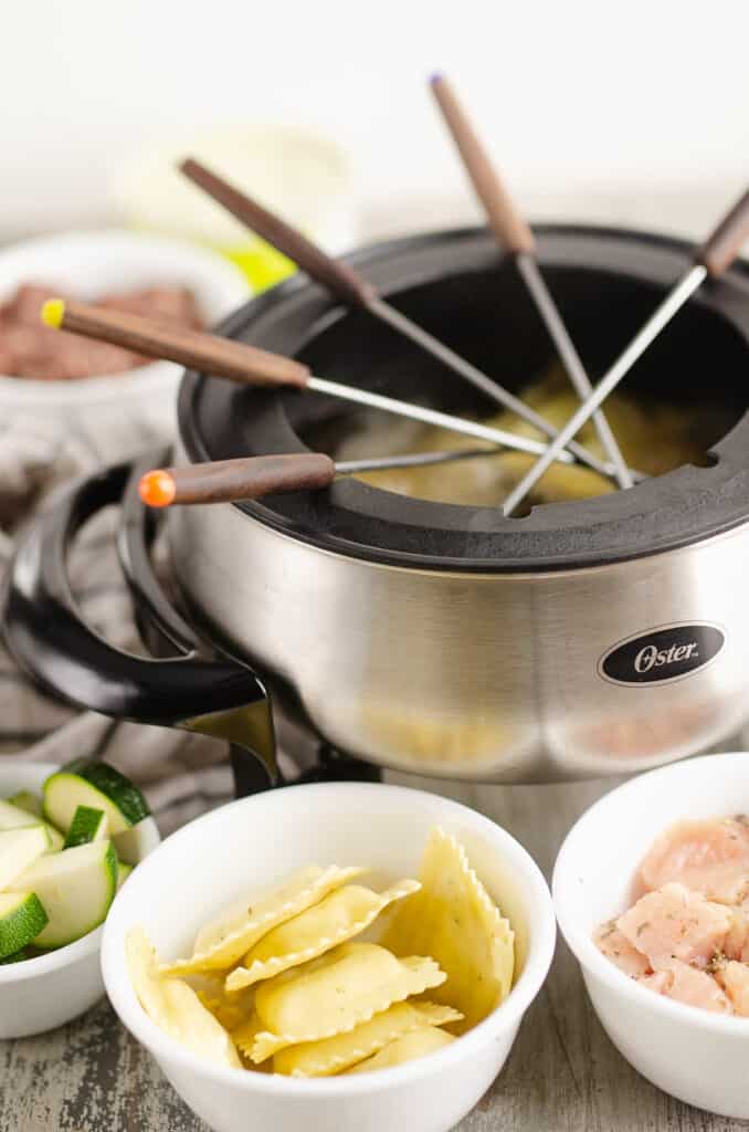 fondue pot filled with forks on table with dippers