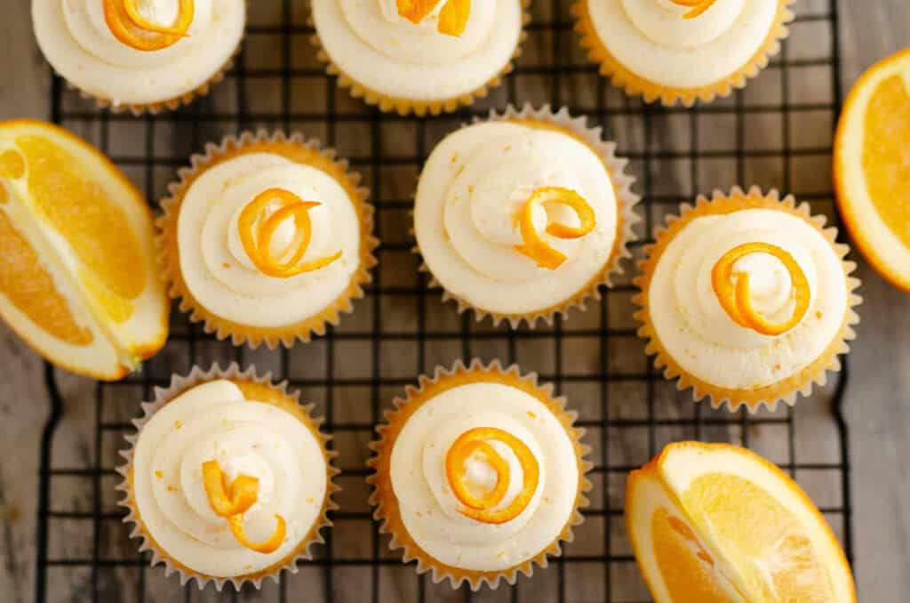 cupcakes on cooking rack with oranges
