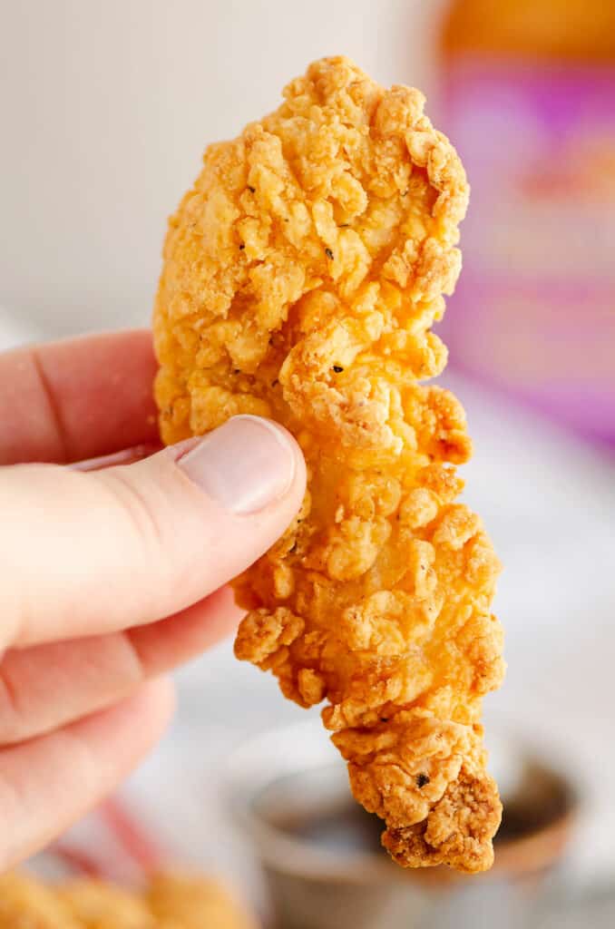 crispy chicken strip held in hand