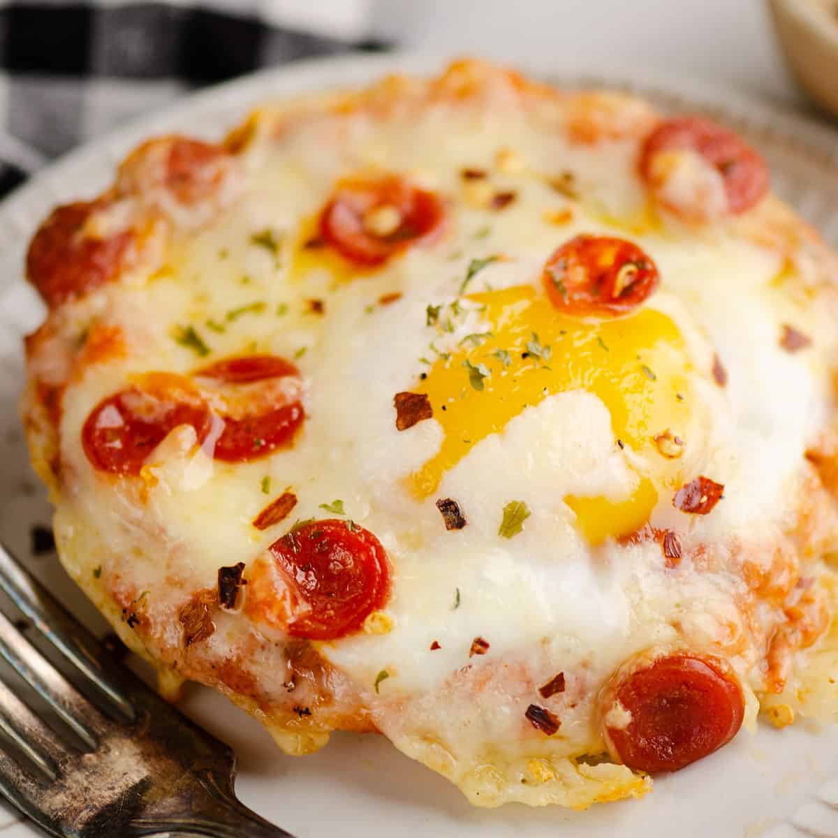 english muffin breakfast pizza on plate with fork