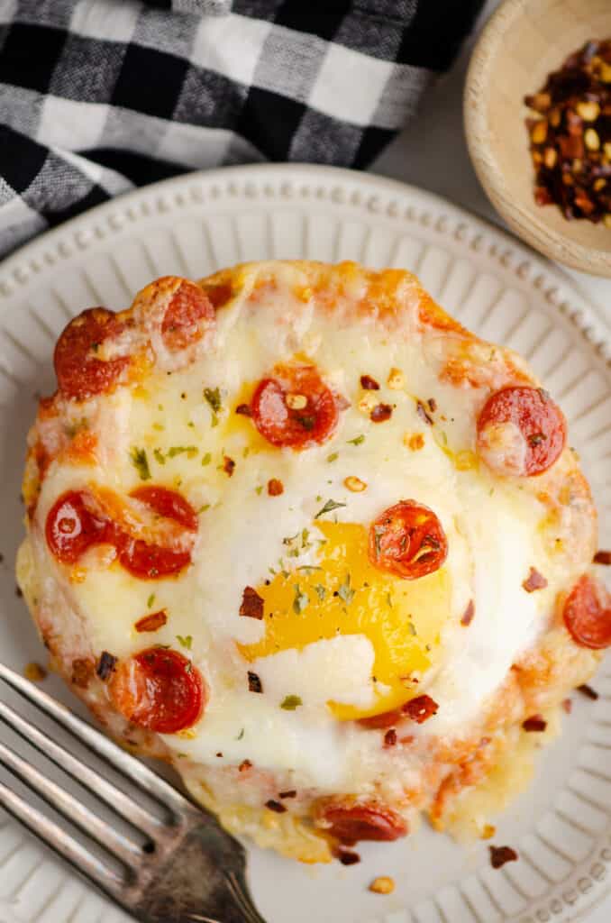 english muffin breakfast pizza on plate with gingham napkin