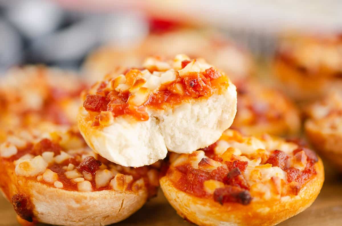 bagel bites stacked on cutting board with bite taken out