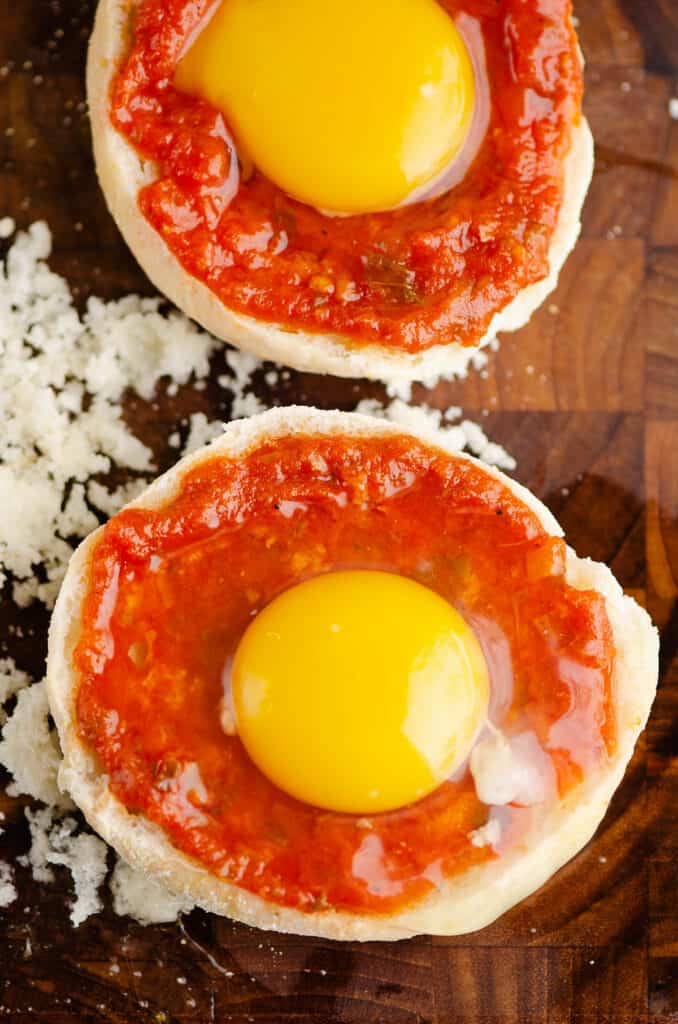 egg yolk over pizza sauce topped english muffin
