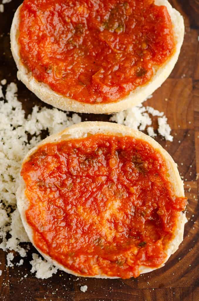 pizza sauce spread on english muffin halves