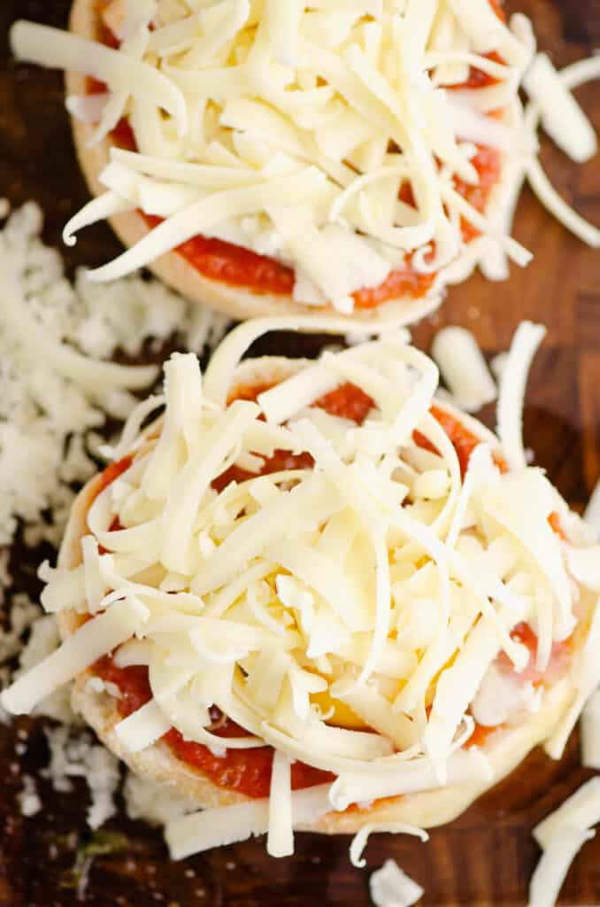 shredded cheese on top of pizza english muffins
