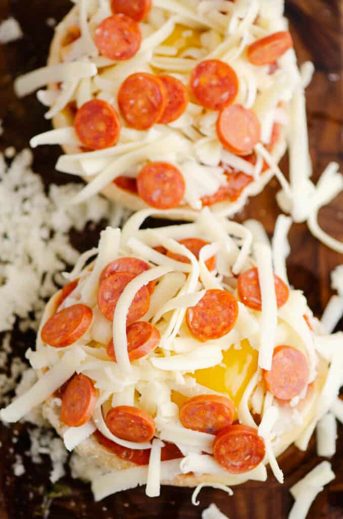 mini pepperoni cheese and egg english muffin pizzas on cutting board