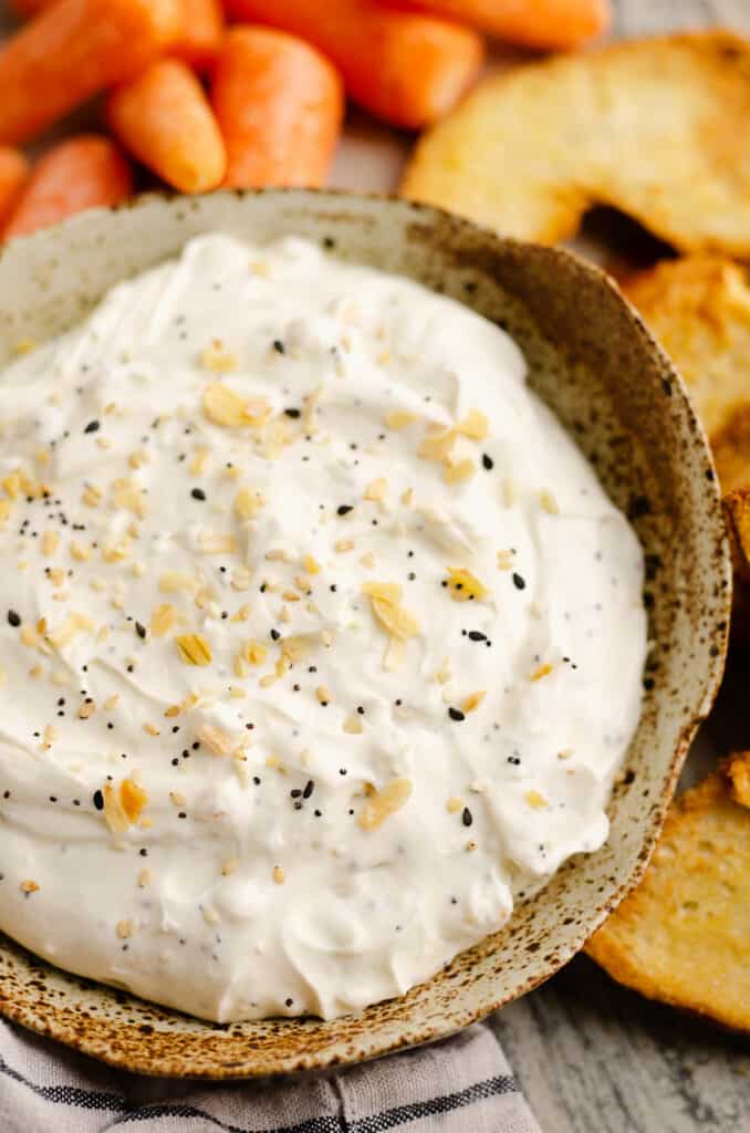 bowl of everything bagel dip served with carrots and bagel chips