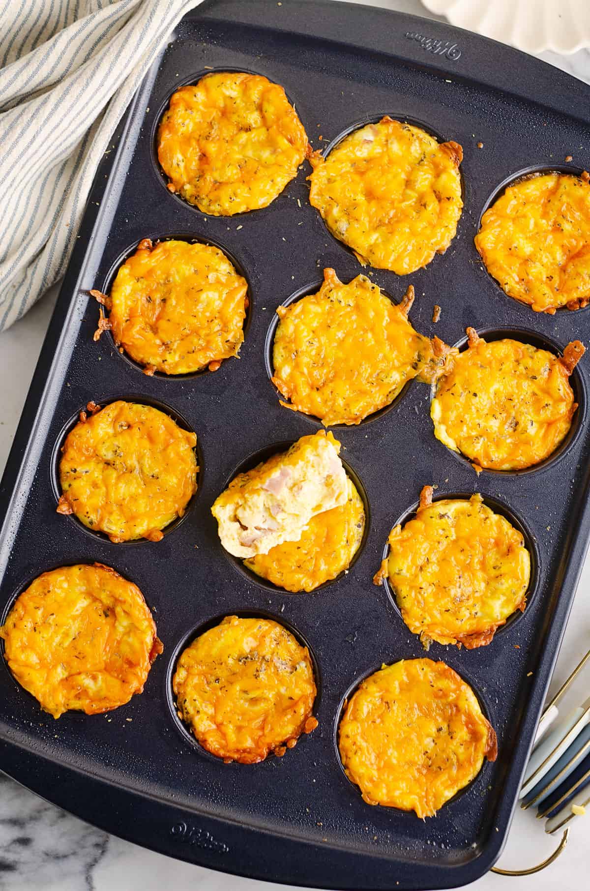 egg bites in muffin tin with one half removed